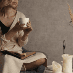Lady with coffee mug sitting in her home with candles